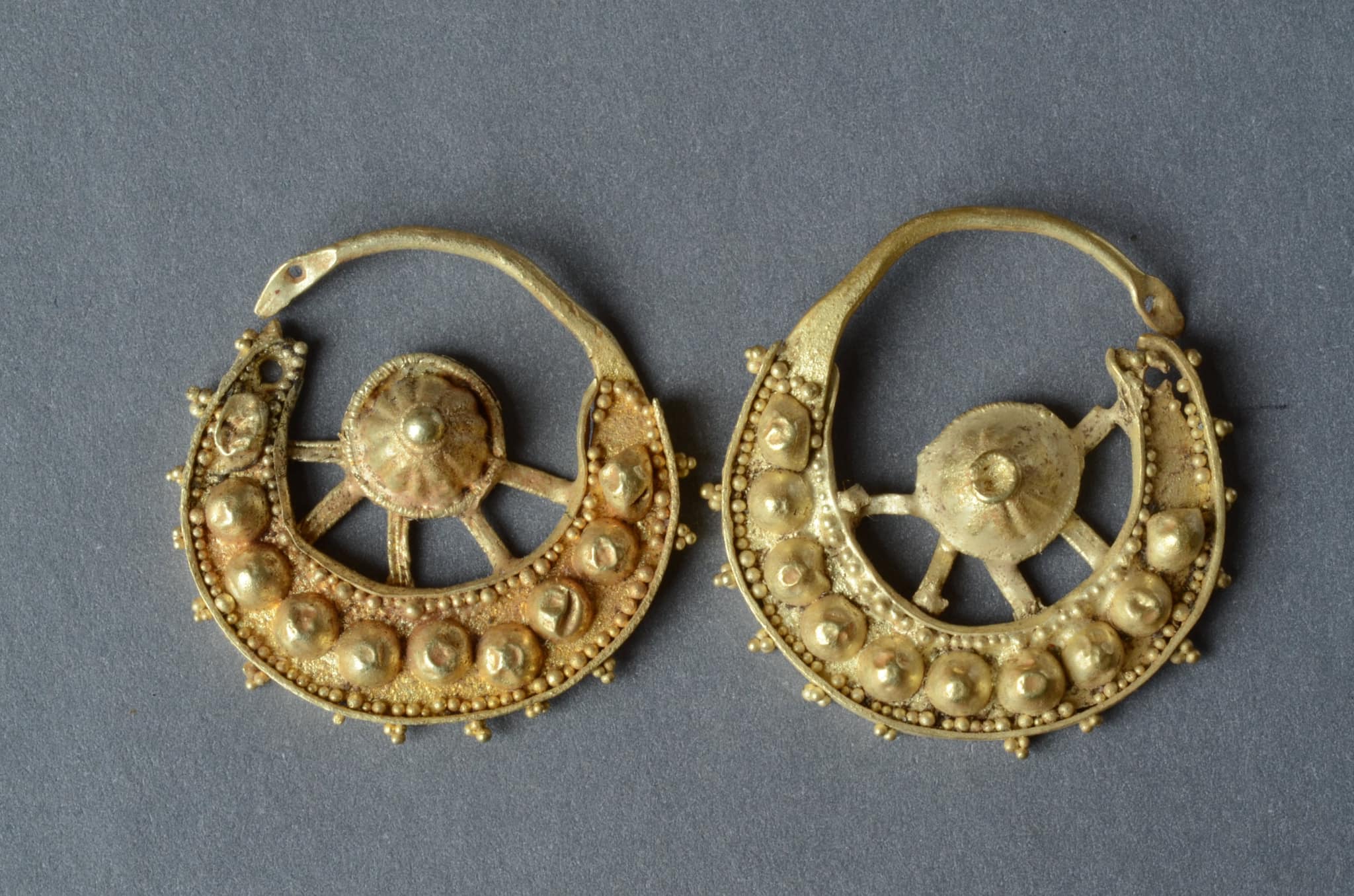 Golden earrings with images of the sun and the crescent moon